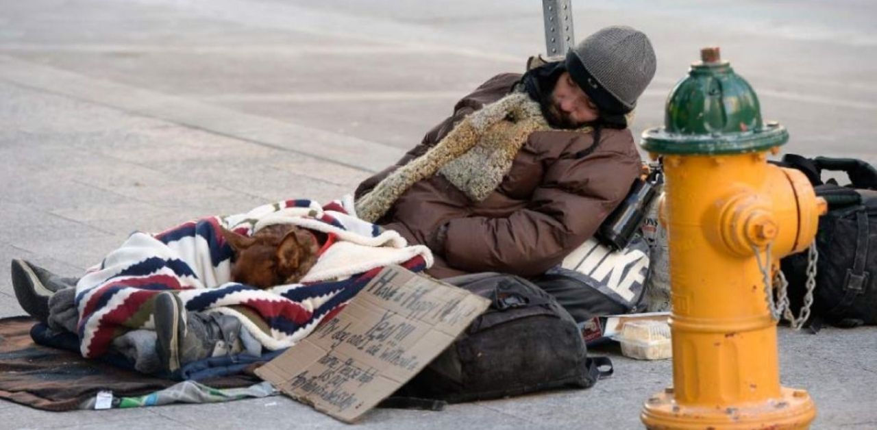 Un senzatetto e il suo cucciolo si aggrappano l'uno all'altro mentre cercano di sopravvivere al freddo