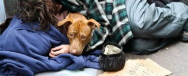 Un senzatetto e il suo cucciolo si aggrappano l'uno all'altro mentre cercano di sopravvivere al freddo