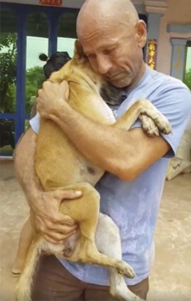 uomo abbraccia cane